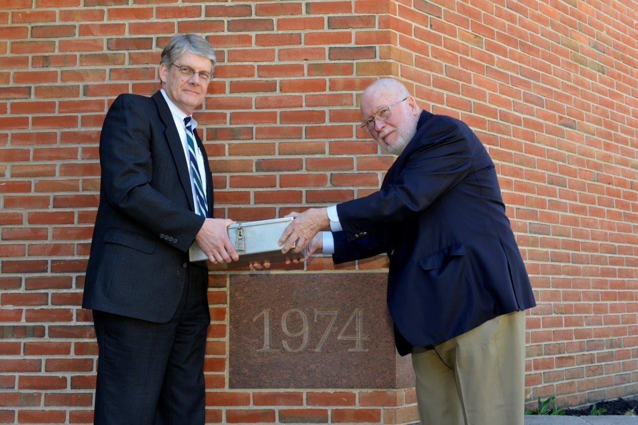 Jerry Parker and Michael McElroy both holding the time capsule.