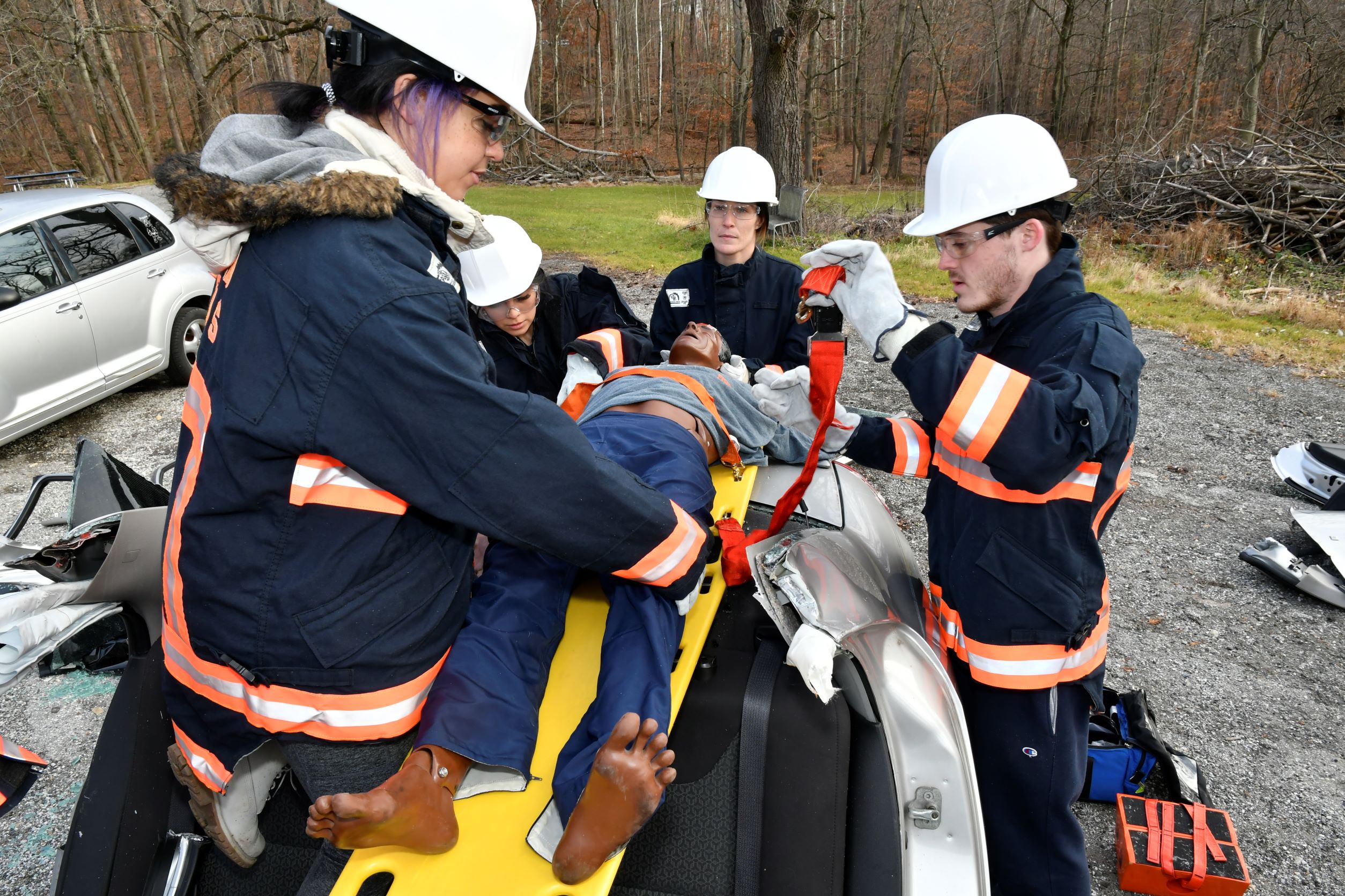 Four EMS-100 students extricate a simulated male manikin from a car opened with extrication rescue tools from Broomall Fire Company Rescue 53