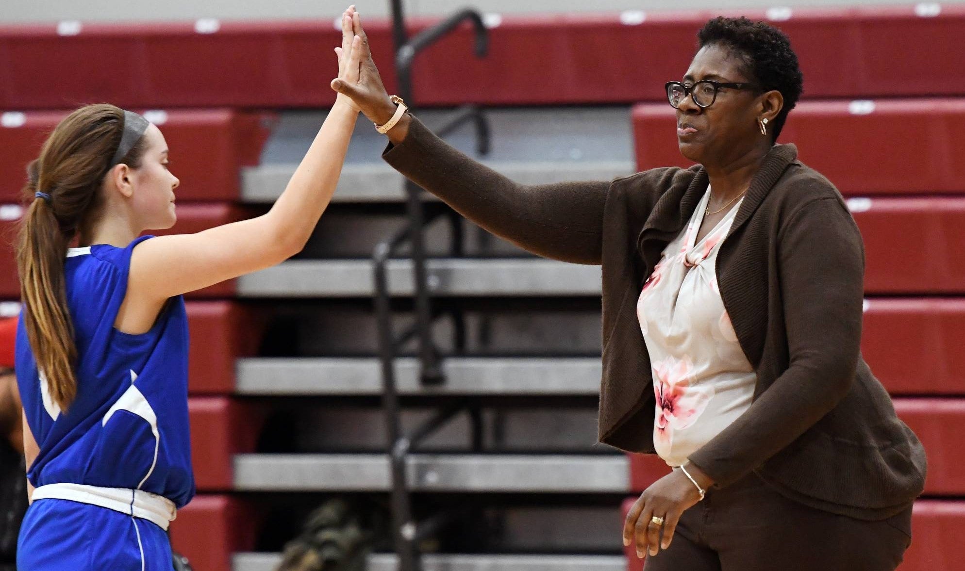 Women's Basketball photo of coach high-fiving player