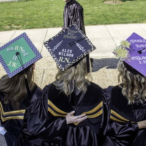 Students with customized caps in green, black and purple colors