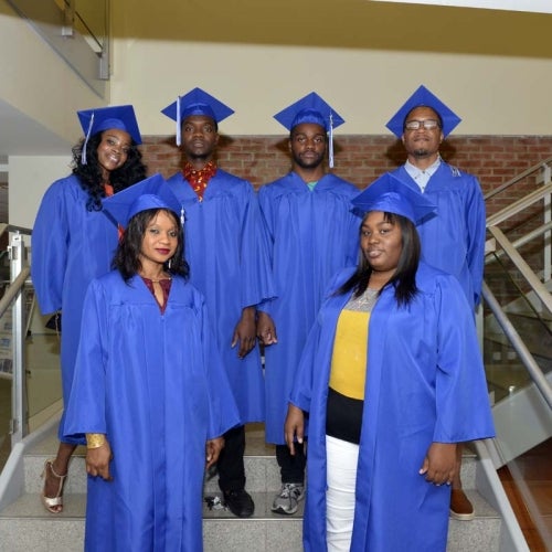 Graduates posing on staircase in the STEM building.