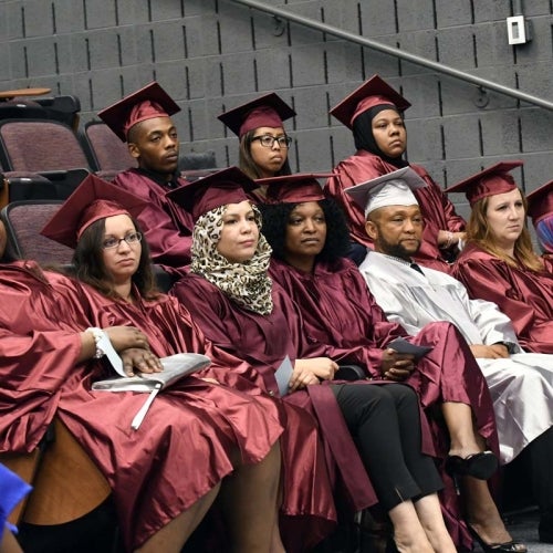 Graduates seated in auditorium.