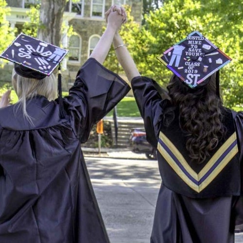 Graduates with arms raised