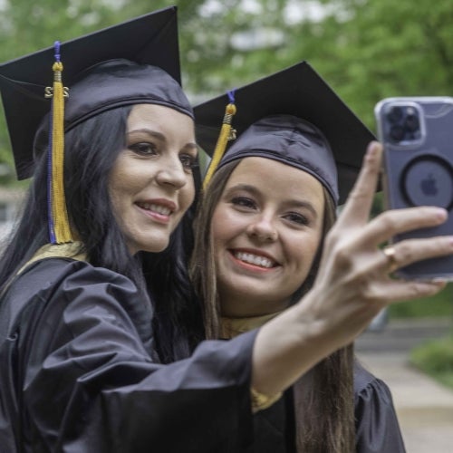 Commencement 5 two grads taking selfie