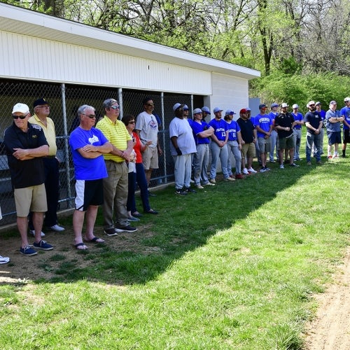 Current and former players lined up in front of dugout