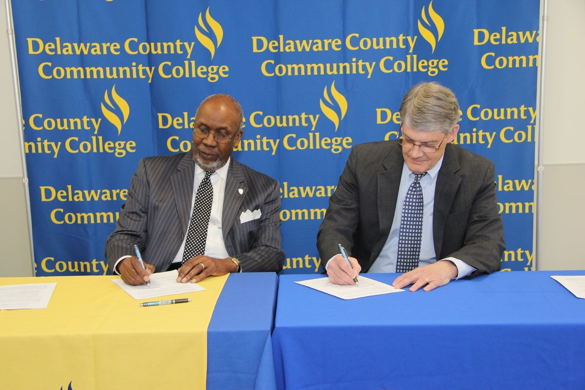 Dr. Frank G. Pogue, Interim President at Cheyney University, and Dr. Jerry S. Parker, President of Delaware County Community College, sign a guaranteed admission and core-to-core transfer agreement between their two schools