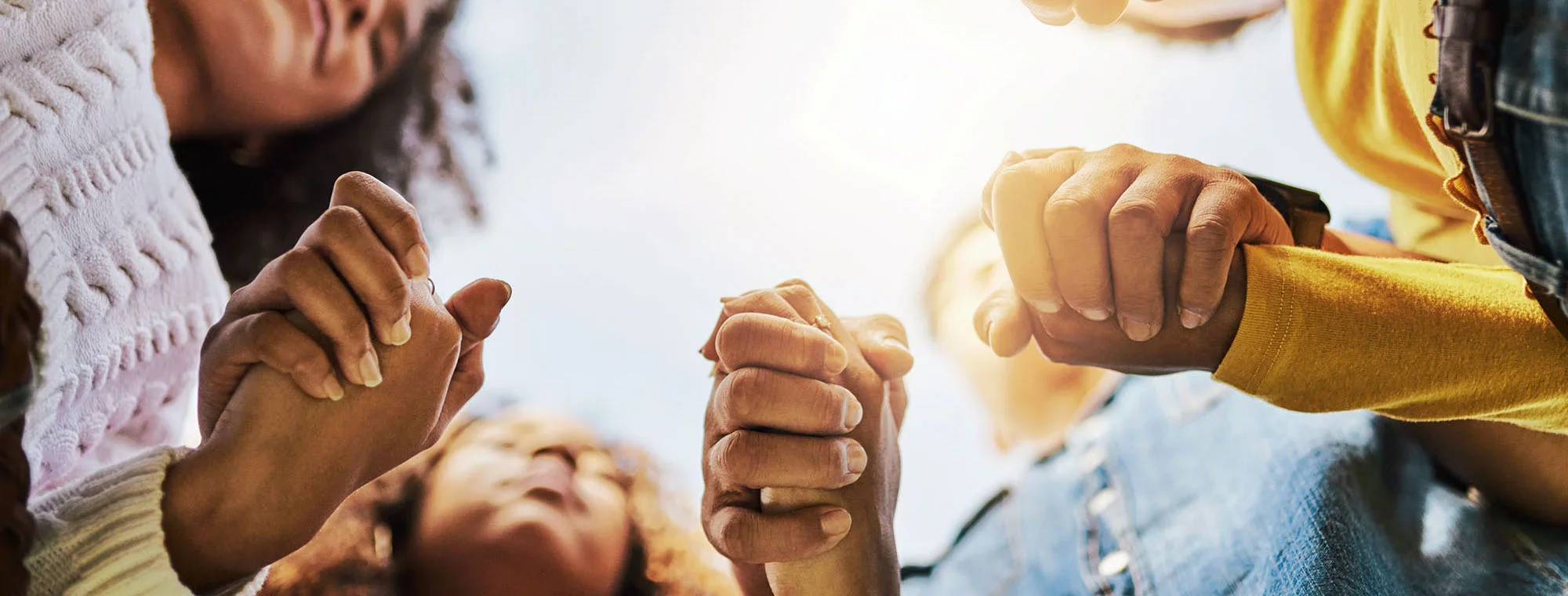 A diverse group of people holding hands in a circle, symbolizing unity, support, and community.