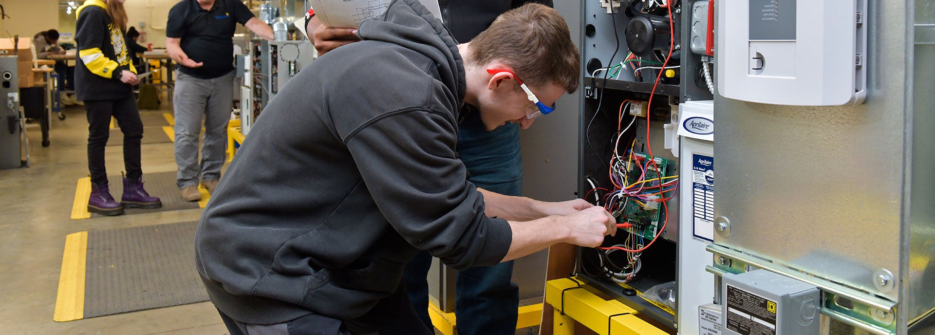 Male student working on HVAC system in classroom