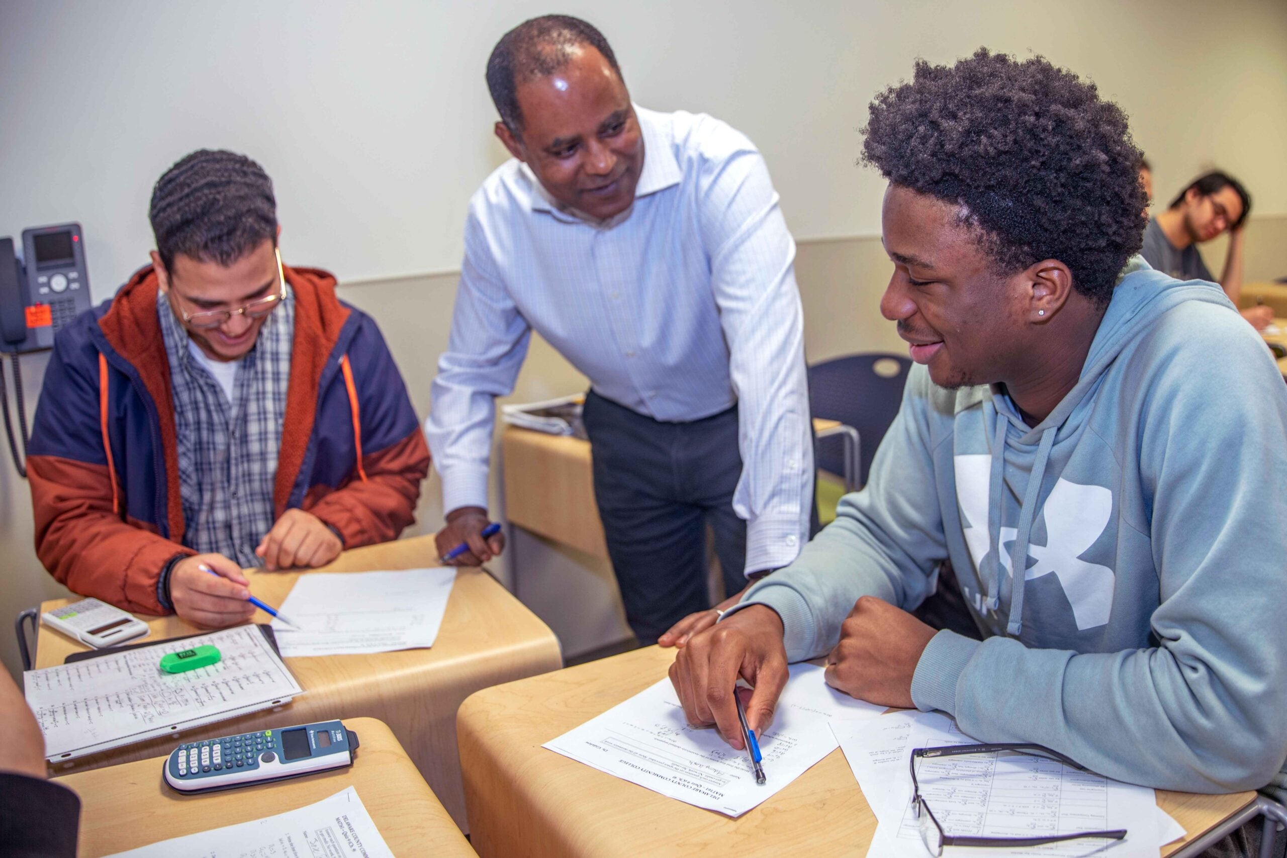 professor working with two students in classroom