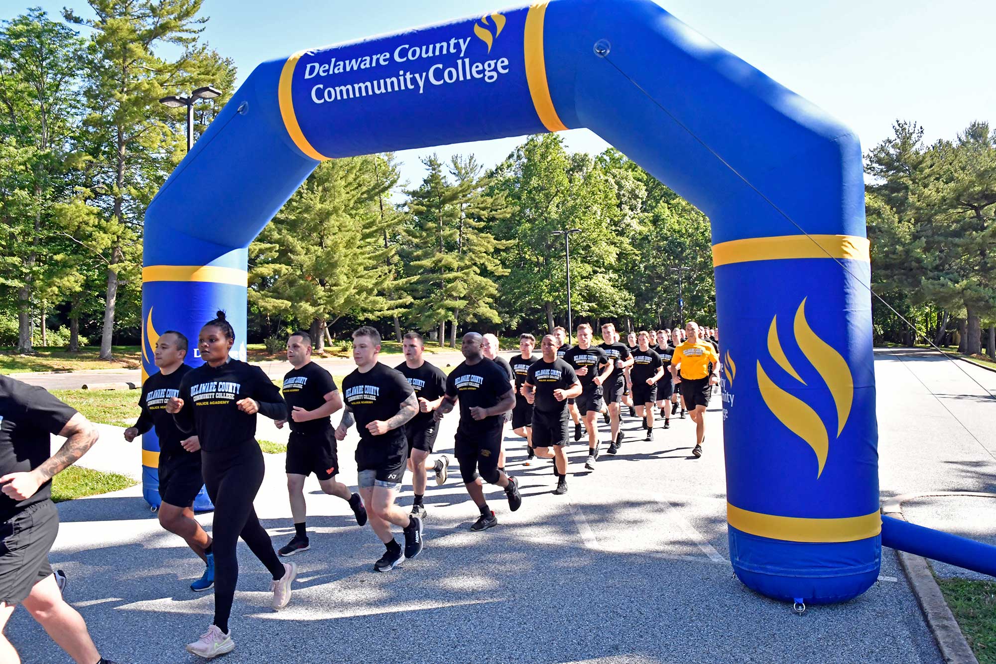 Students running under college race archway