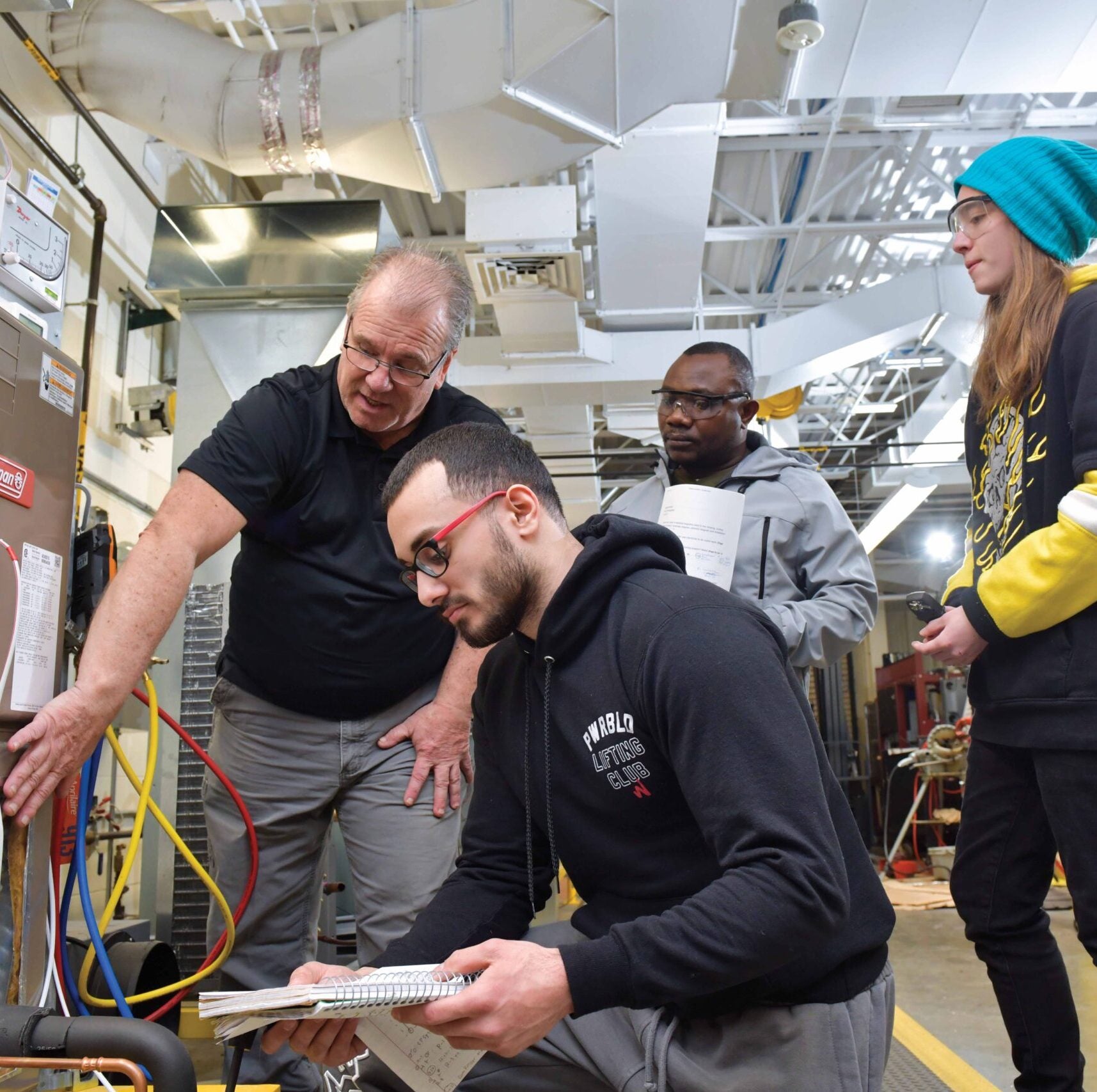 Instructor guiding students on HVAC system setup