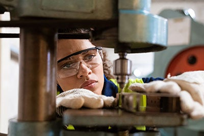 Female apprentice using advanced manufacturing machine