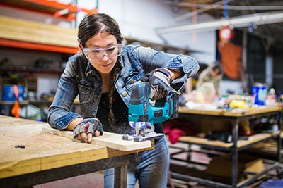 female carpenter using a saw