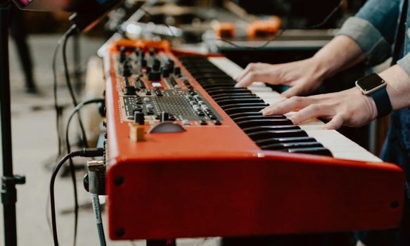 hands playing electric keyboard