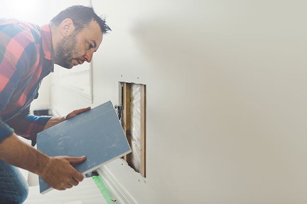 Man repairing drywall at home