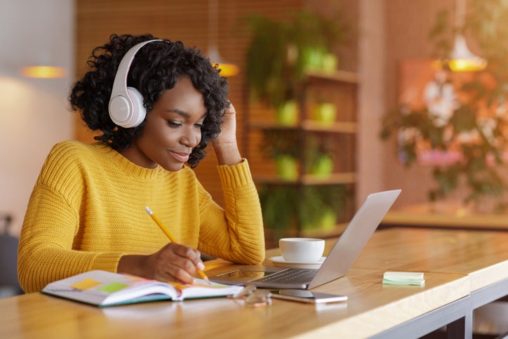 Female working at laptop with headphones on