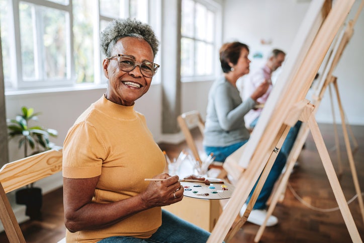 Senior woman sitting at art easel