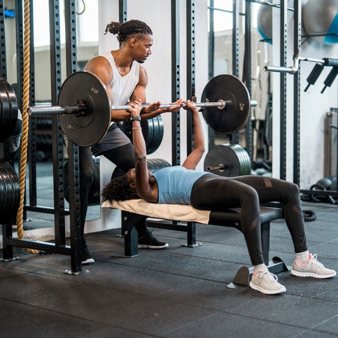 Trainer and trainee lifting wieghts