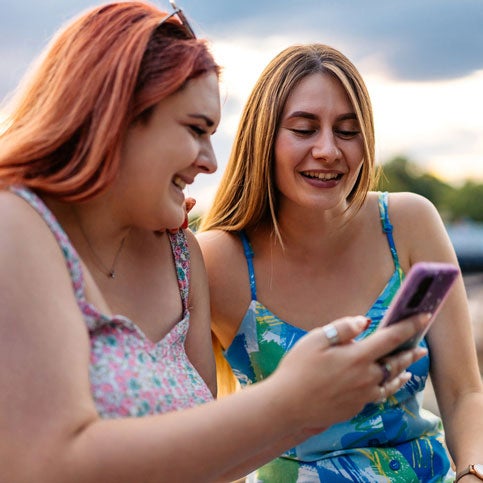 Two friends looking at an iPhone together