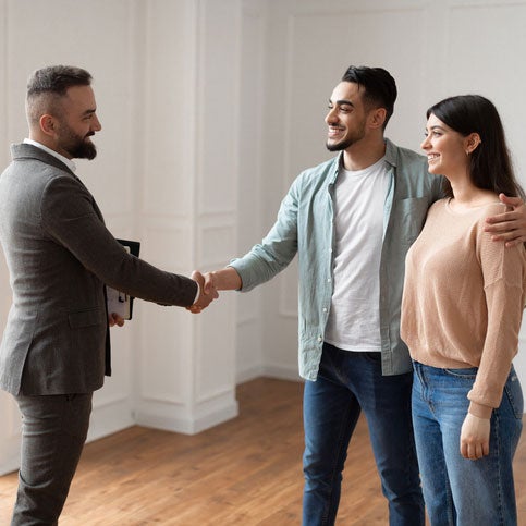 Real Estate agent shaking hands with young couple