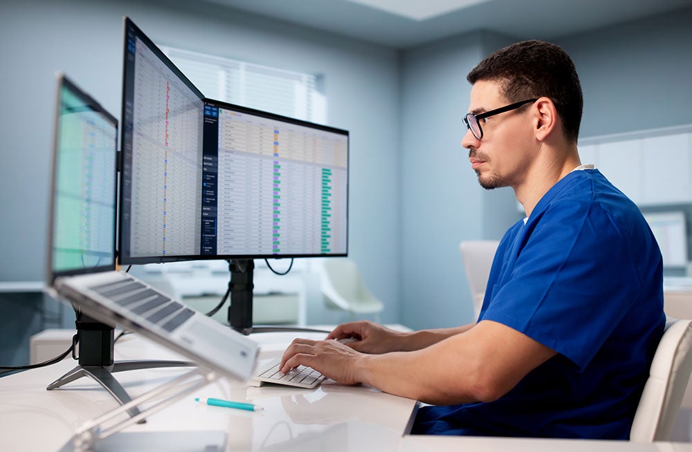 Employee sitting in front of computer screens