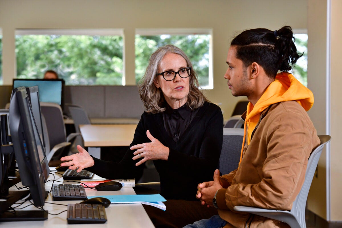 A DCCC student and faculty member view course work on a computer in DCCC's Learning Commons.